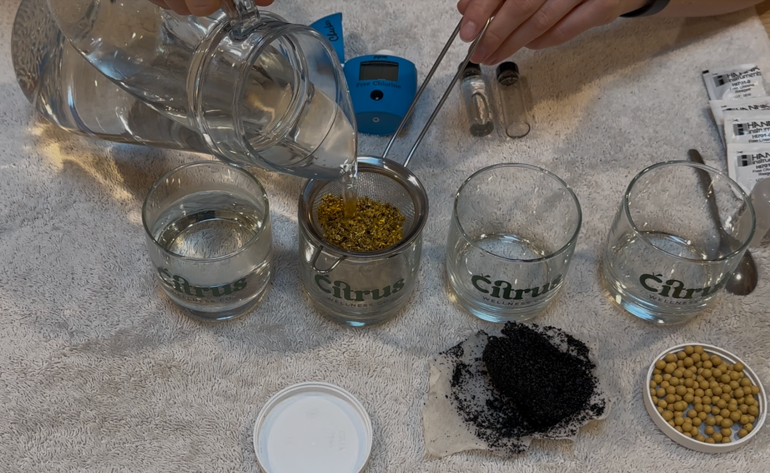 Water being poured through KDF filter media, with activated carbon and vitamic C ready to be tested next